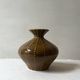 Pyriform vase in glazed ochre ceramic and beads.