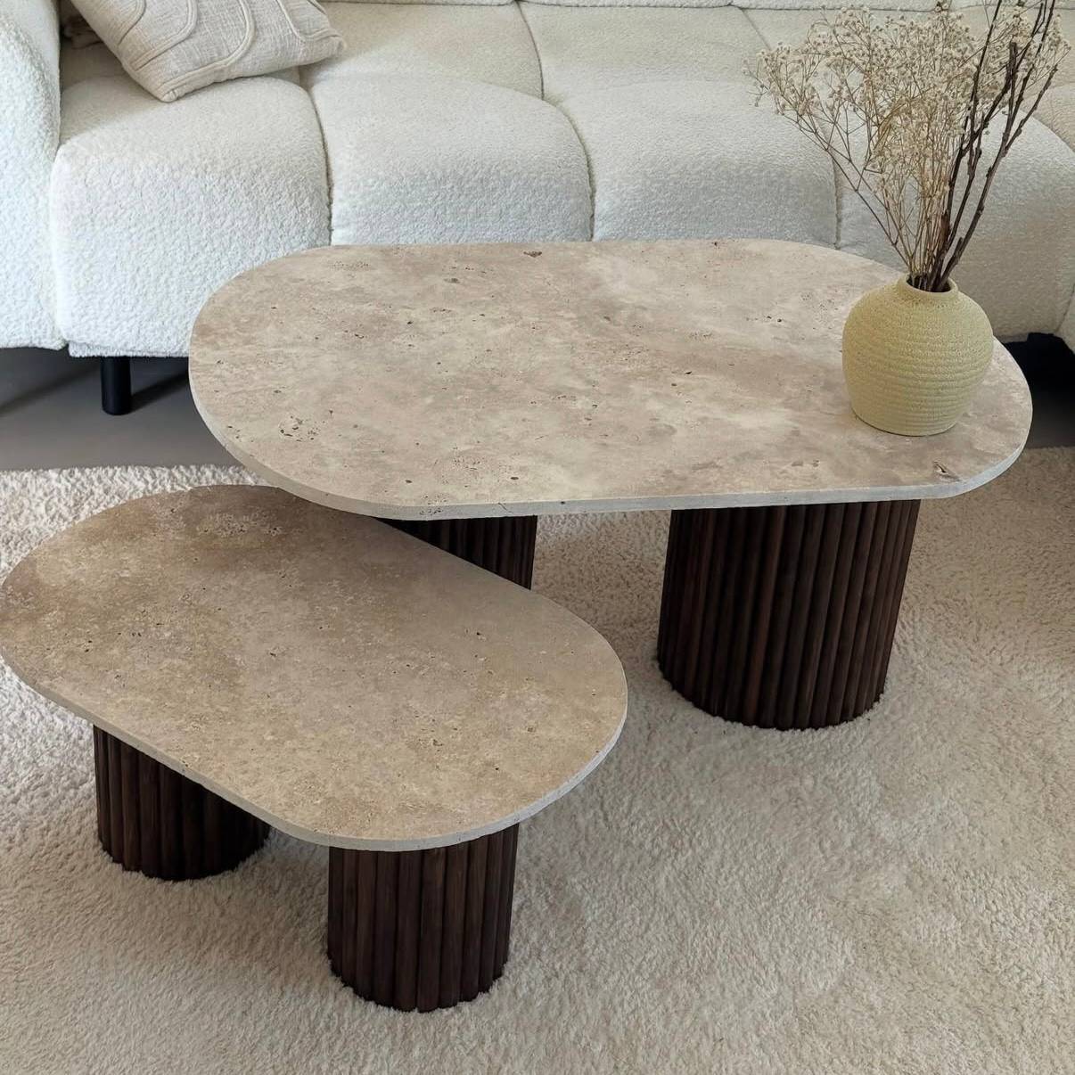 Oval coffee table duo travertine and fluted wooden legs.