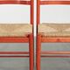 Set of two red vintage wooden chairs from the 1970s with woven rattan seats