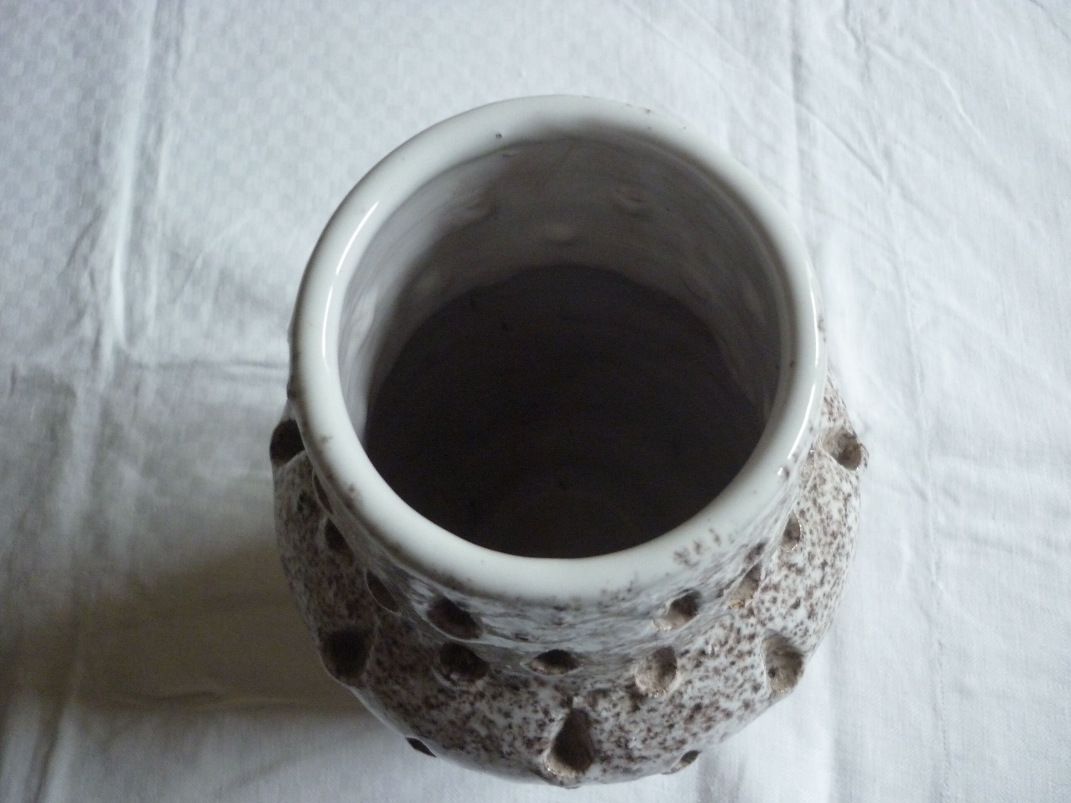 Spotted white ceramic vase with hollow form of tears