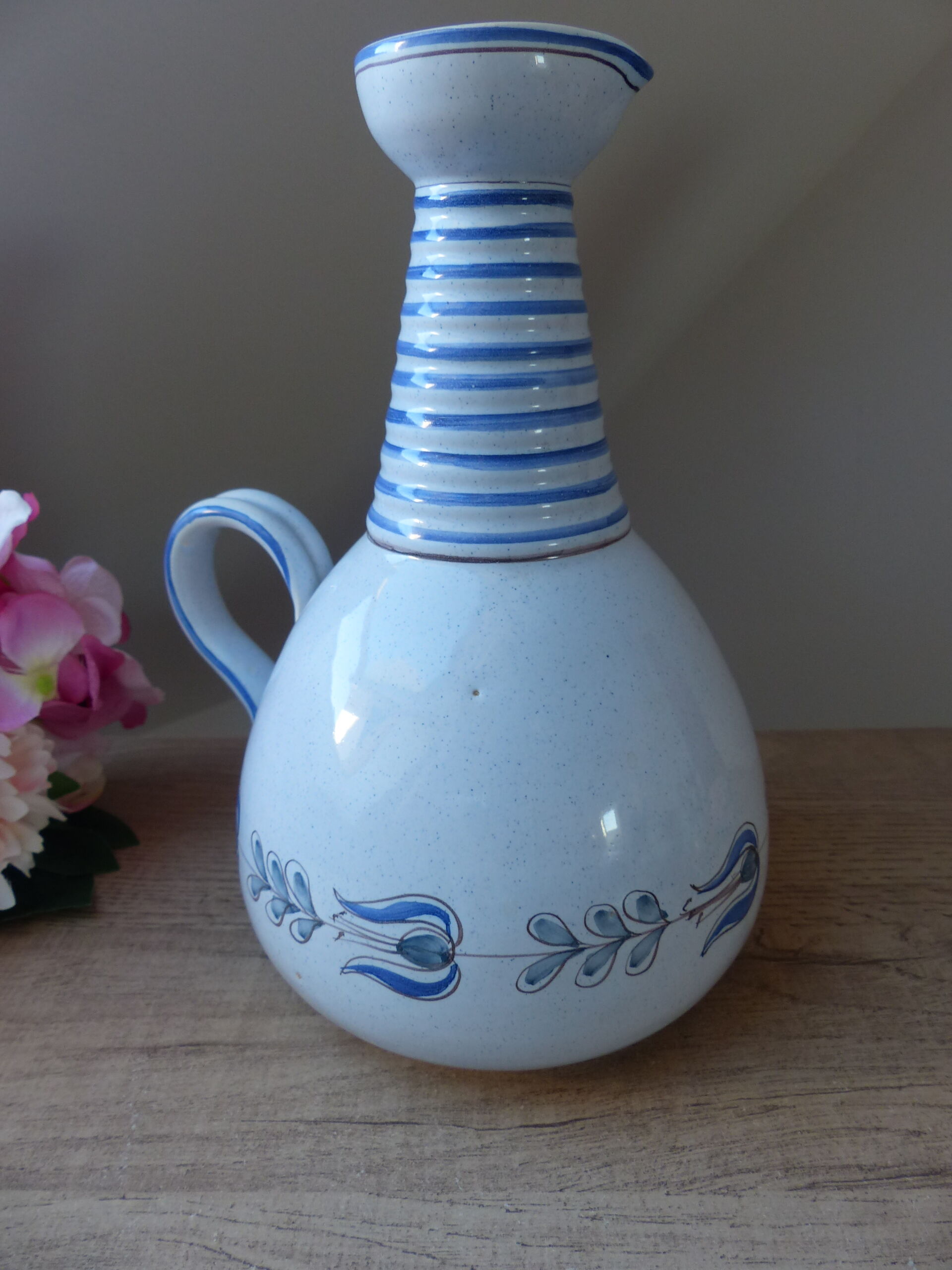 Vintage blue ceramic jug with hand-painted floral decoration.