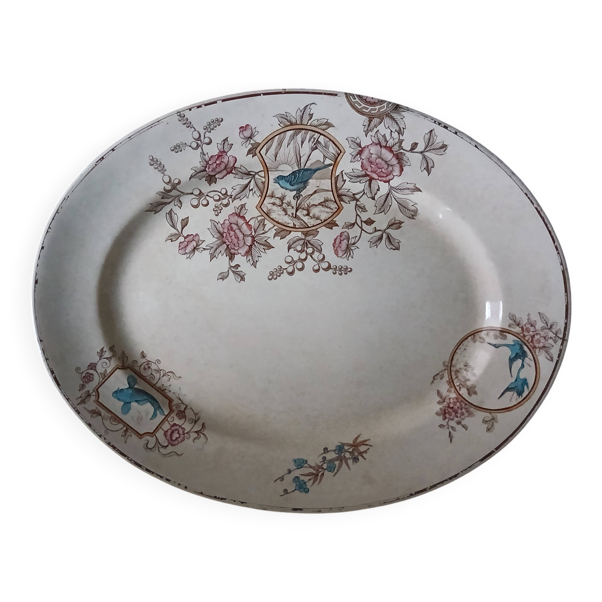 Large antique plate stamped with a fauna and flora pattern.