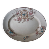 Large antique plate stamped with a fauna and flora pattern.