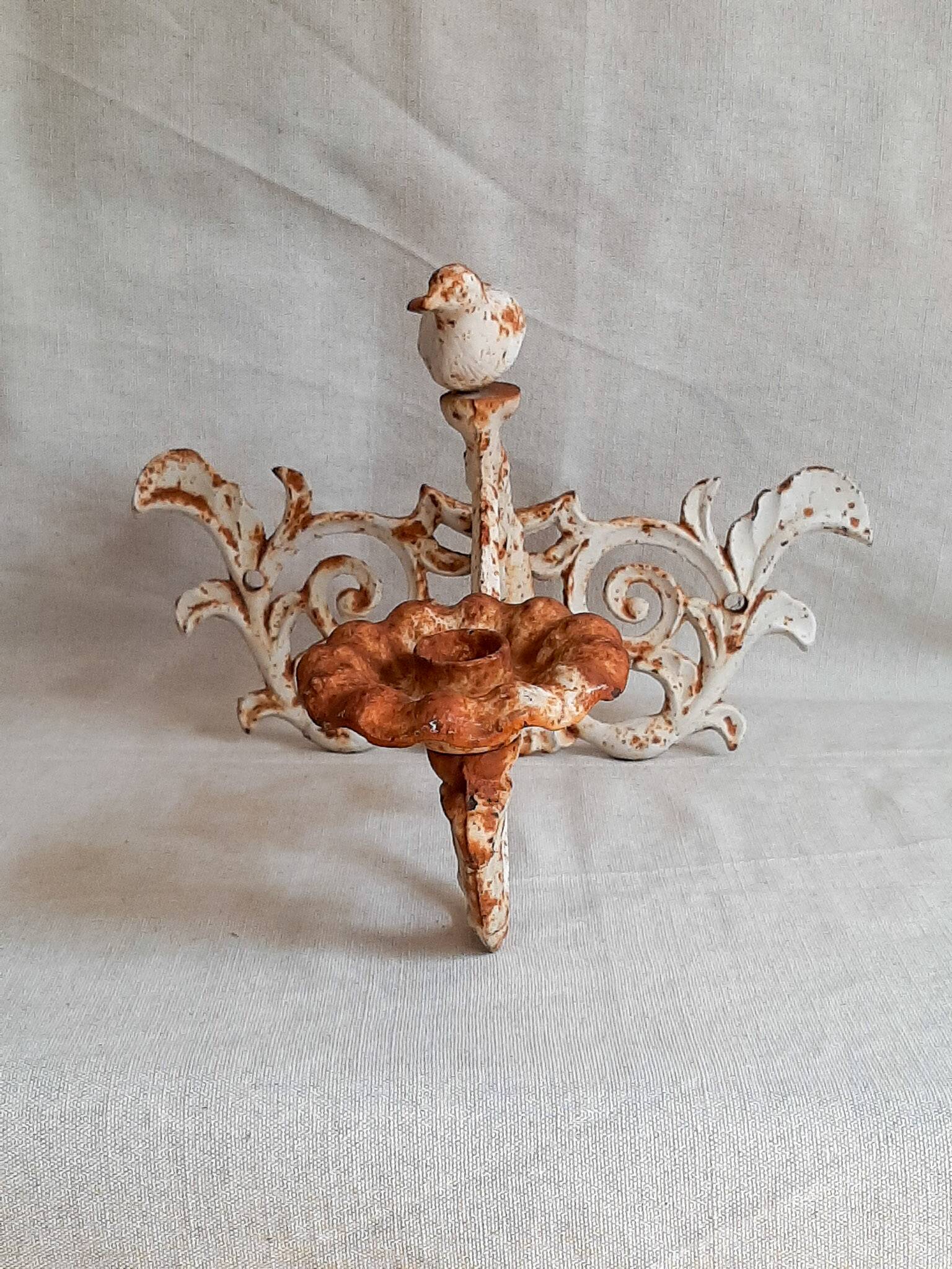 Wall lamp in antique cast iron with bird and scroll decorations.