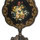 Blackened wooden side table decorated with a painted bouquet of flowers.