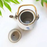 Flowery stoneware teapot with rattan handle.