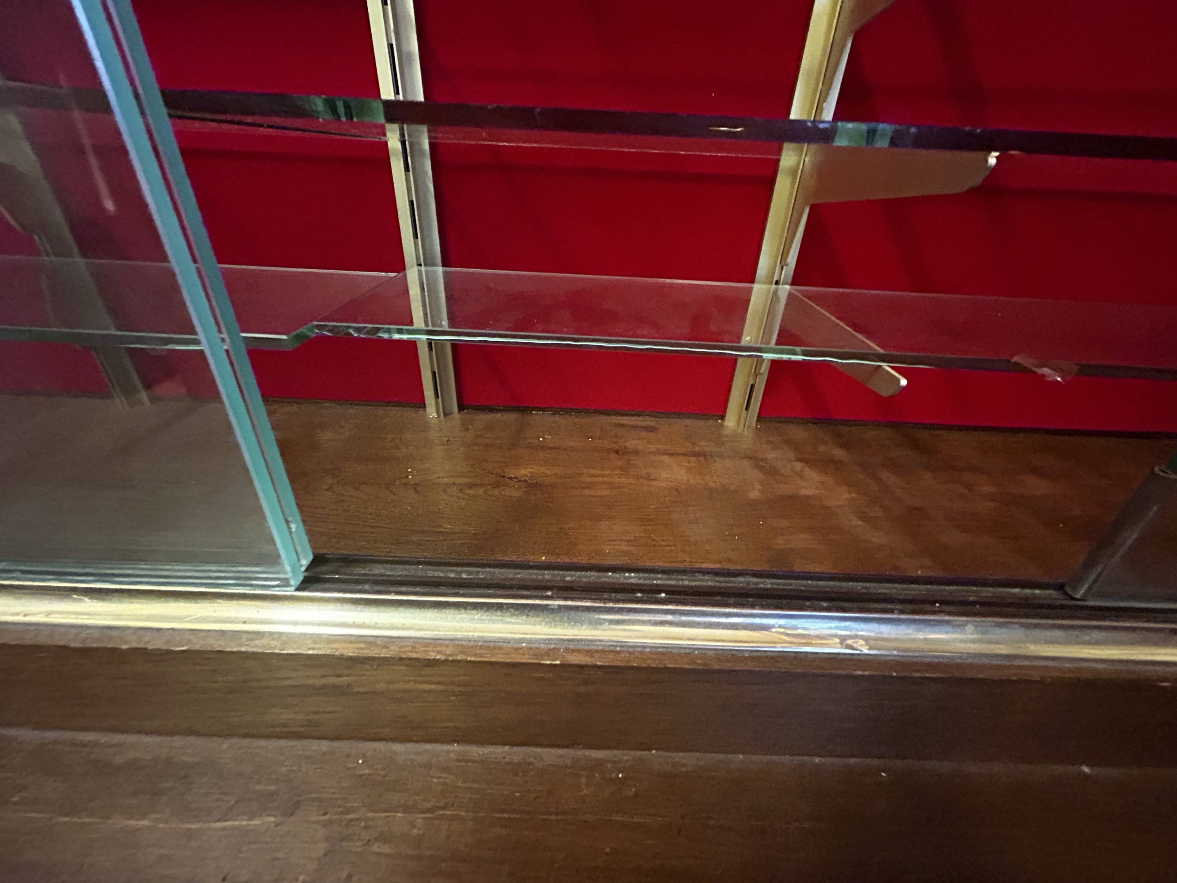 Large vintage display cabinet in wood and glass – red background, 15 shelves