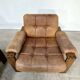 A lovely living room set comprising a pair of armchairs, a tan leather sofa and its ottoman