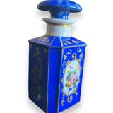 Perfume bottle in porcelain of old paris blue background