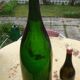 Green blown glass bottle of 58 cm.
