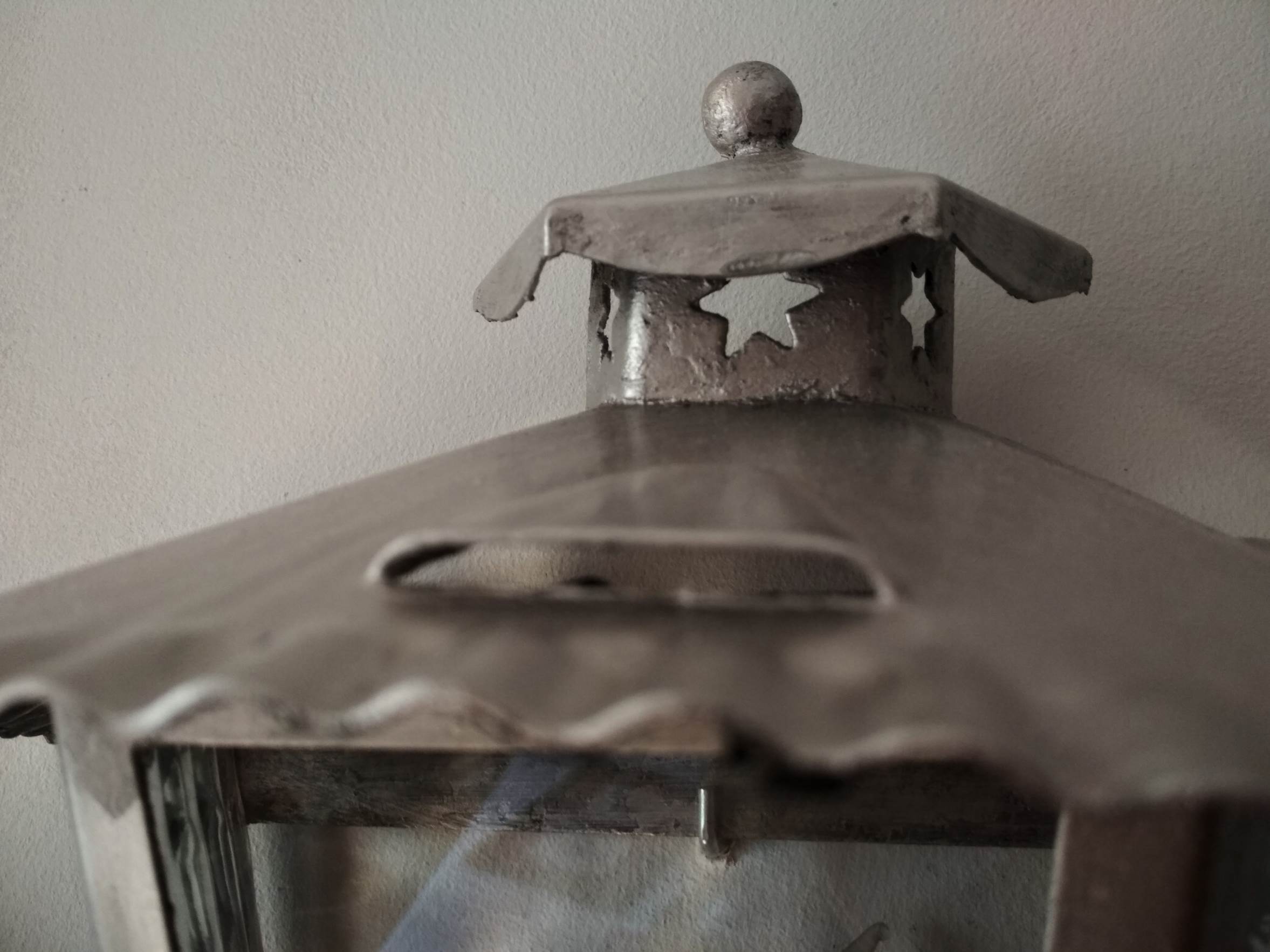 Half grey metal wall sconce and 3 windows