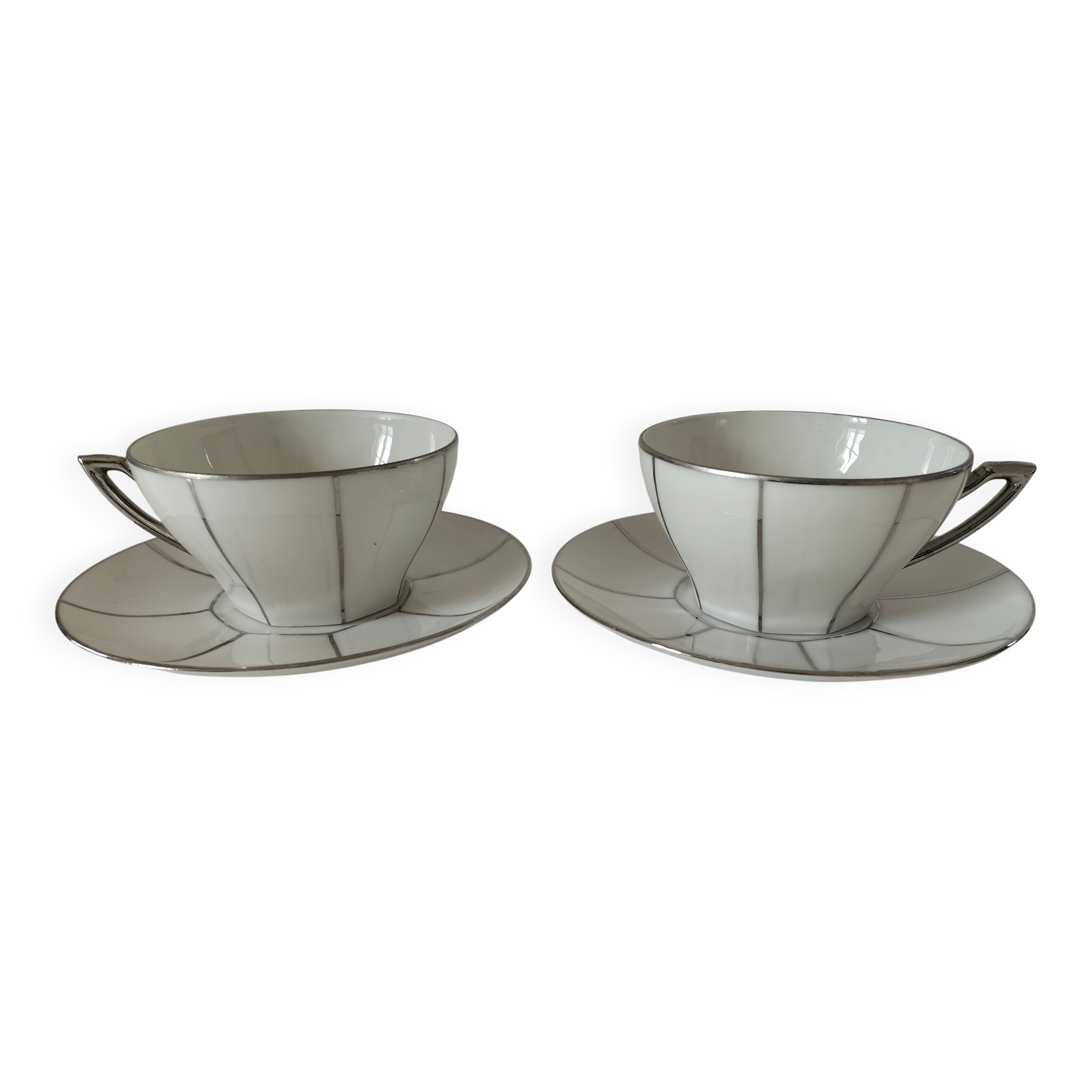 Two Art Deco porcelain cups and saucers with silver trim.