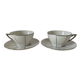 Two Art Deco porcelain cups and saucers with silver trim.