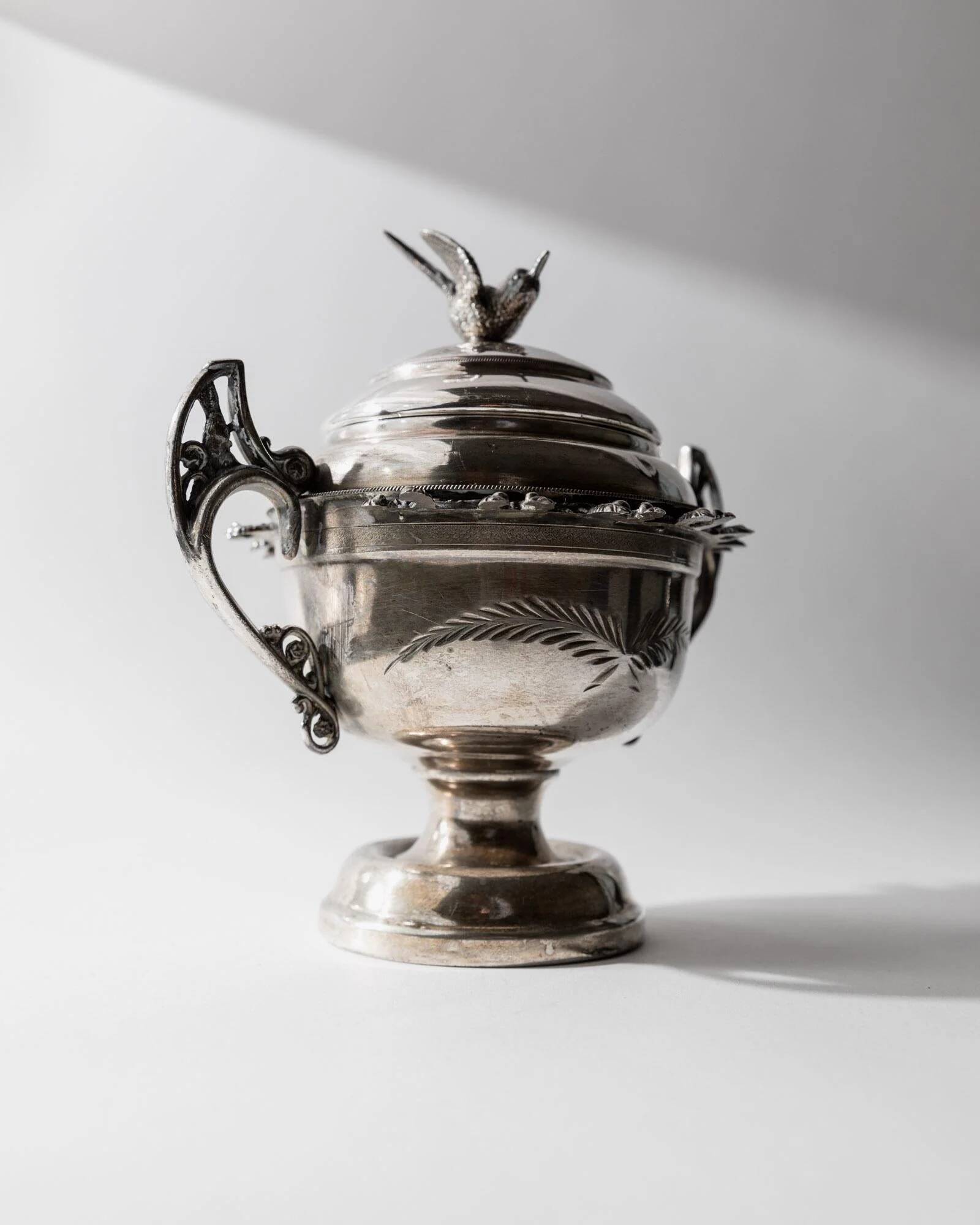 Vintage 1930s silver-plated footed bowl with lid by Warren Rogers New York, featuring a bird motif and ornate details.
