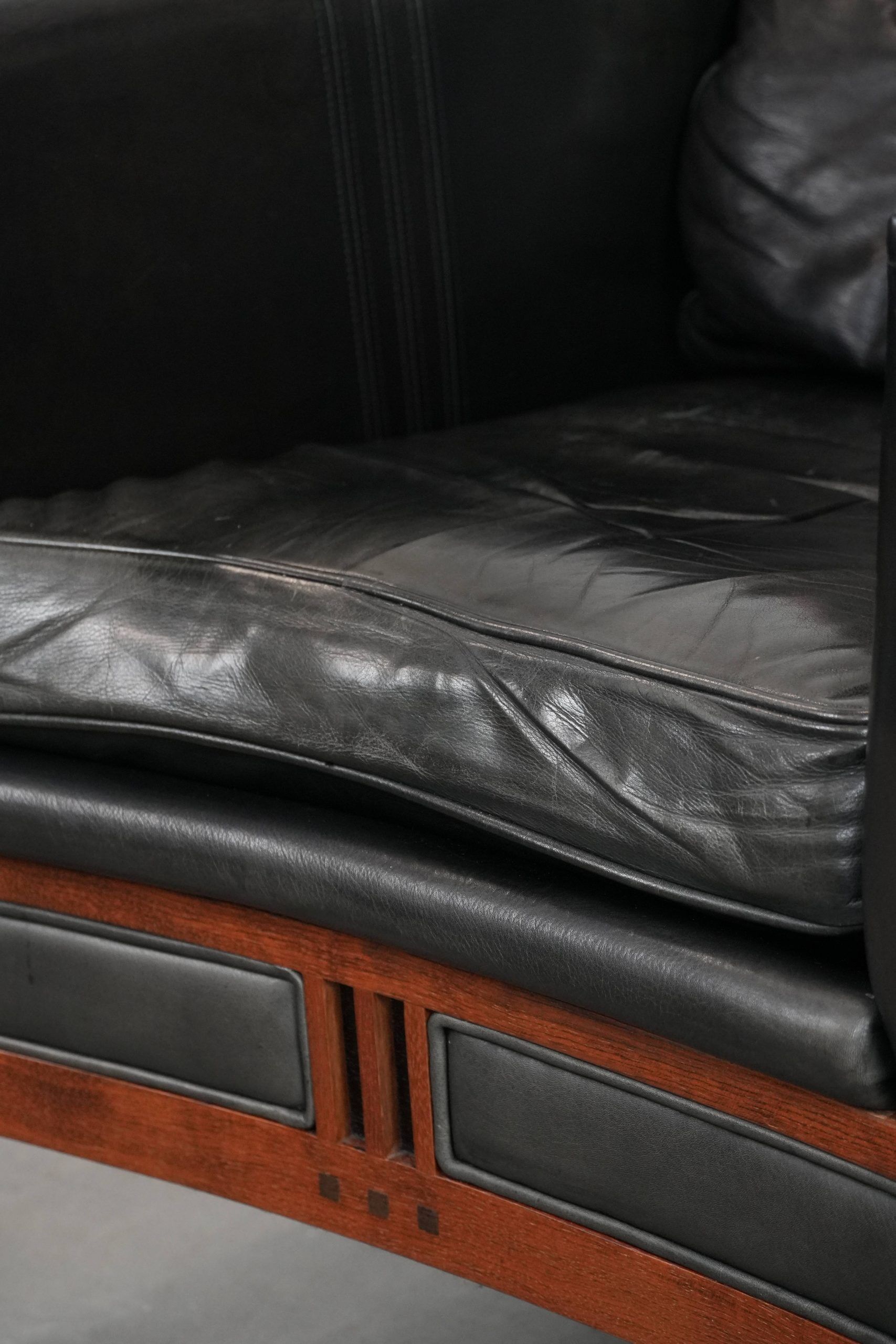 Black cowhide leather and wooden Art Deco design armchair