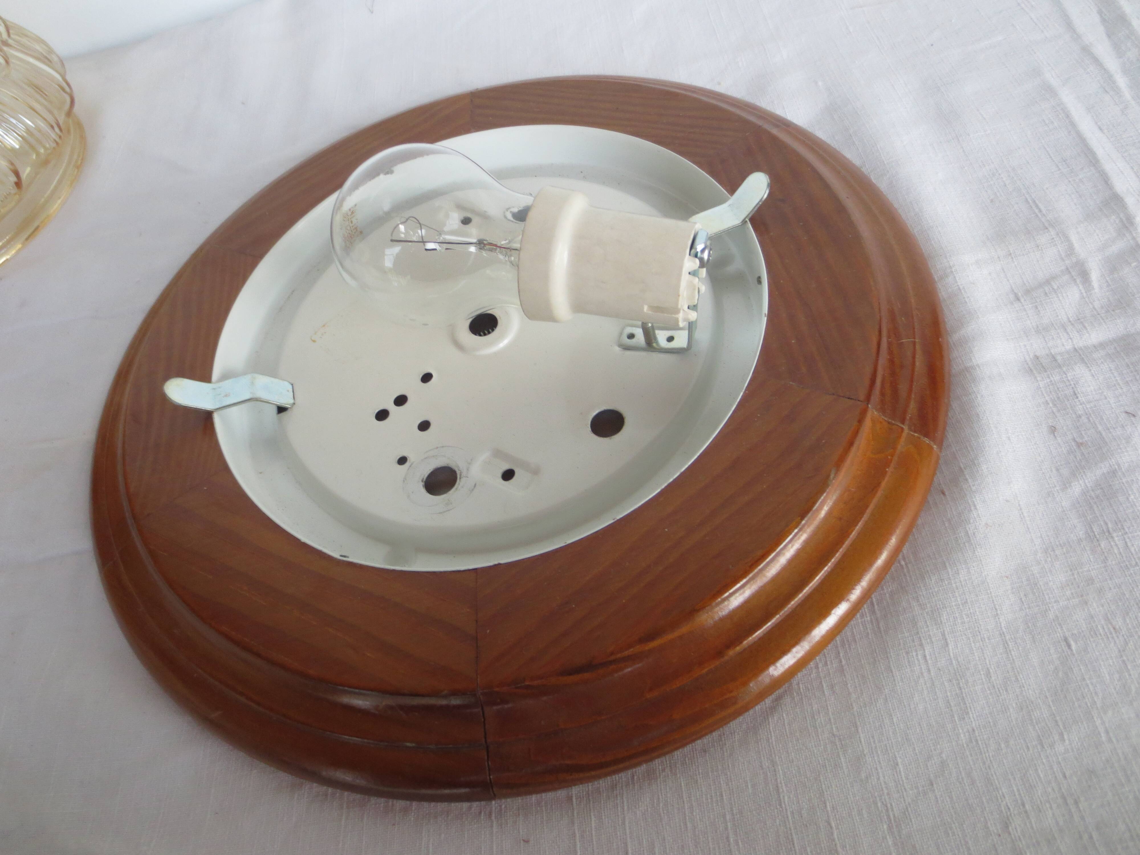 ceiling light with amber glass globe, on a round light wood base