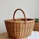 Large vintage woven wicker basket with a central handle.