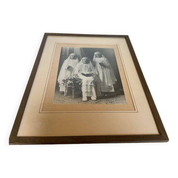 Large frame old photograph of a trio of communicants.