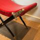 Neoclassical curule stool in red leather, decorated with crossed swords in bronze and metal covered in black leather.