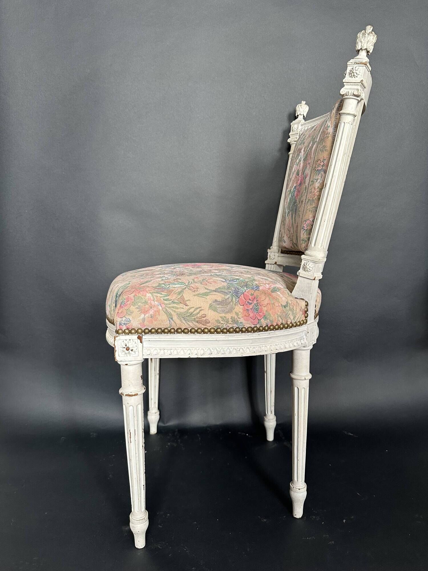 Antique Louis XVI style chair with patinated wood and floral fabric.