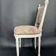 Antique Louis XVI style chair with patinated wood and floral fabric.