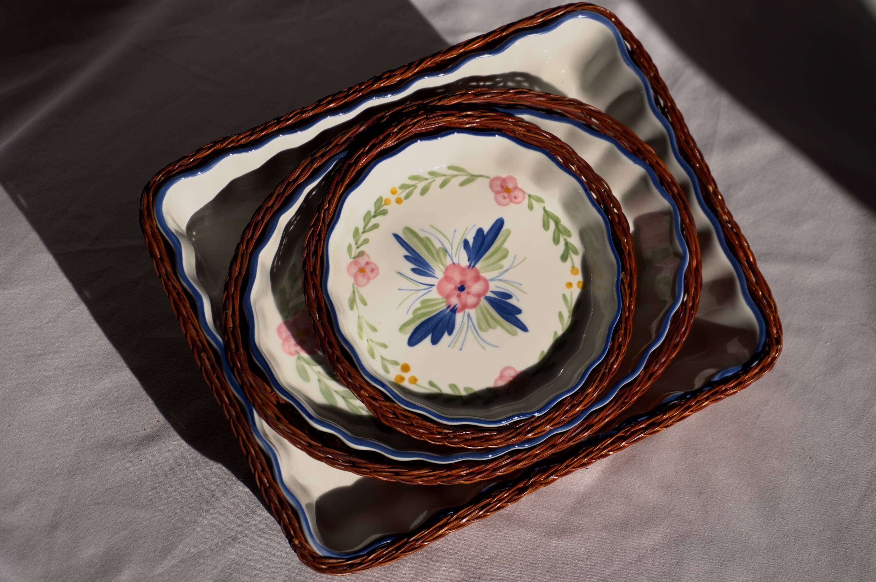 Set of 3 porcelain dishes with floral decorations, with wicker supports.