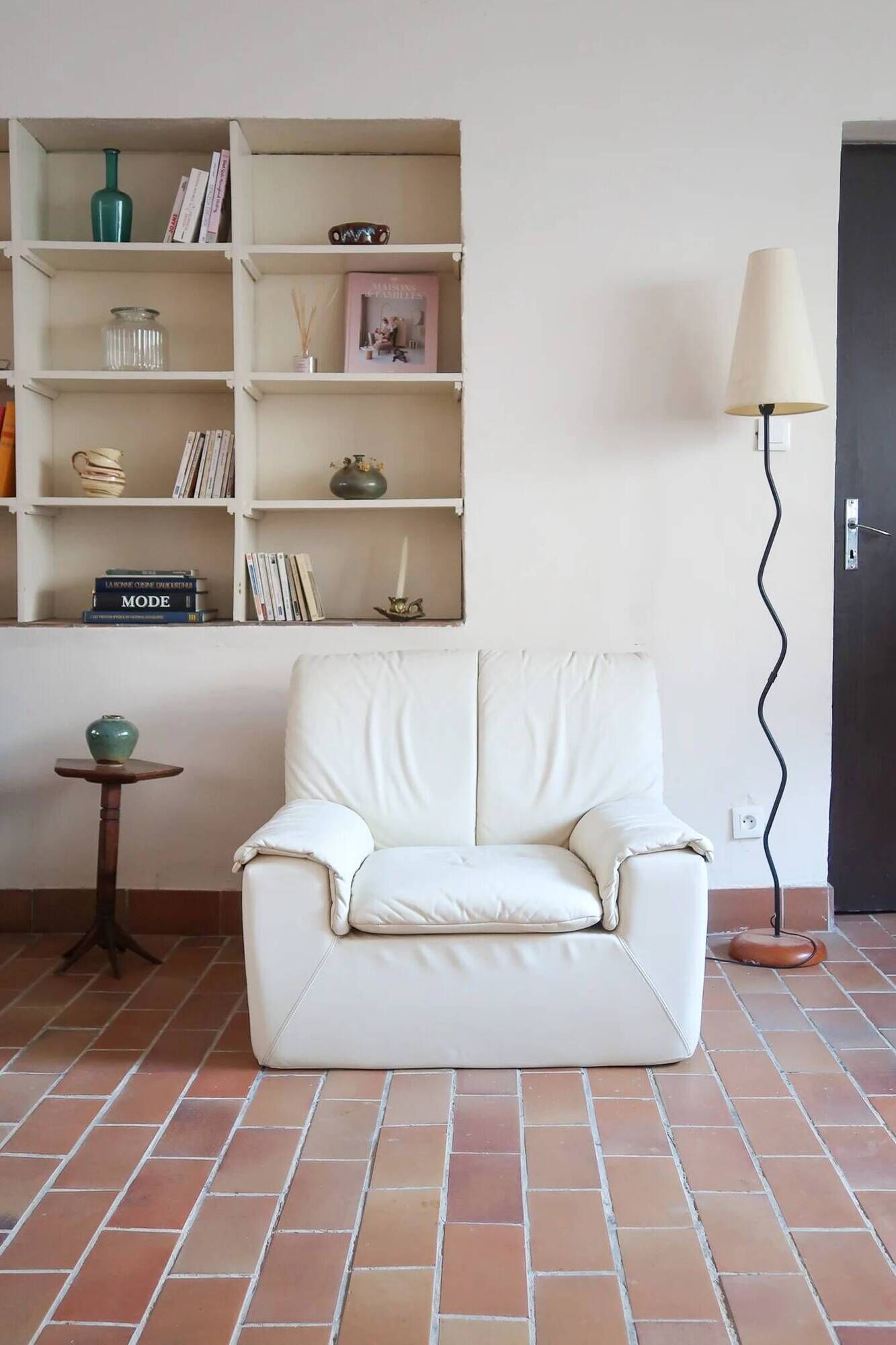 Cinna armchair in cream leather, bolstered armrests, 1970s.