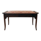 Antique wooden storage bench with red fabric.