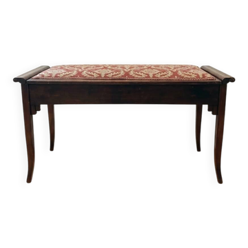 Antique wooden storage bench with red fabric.