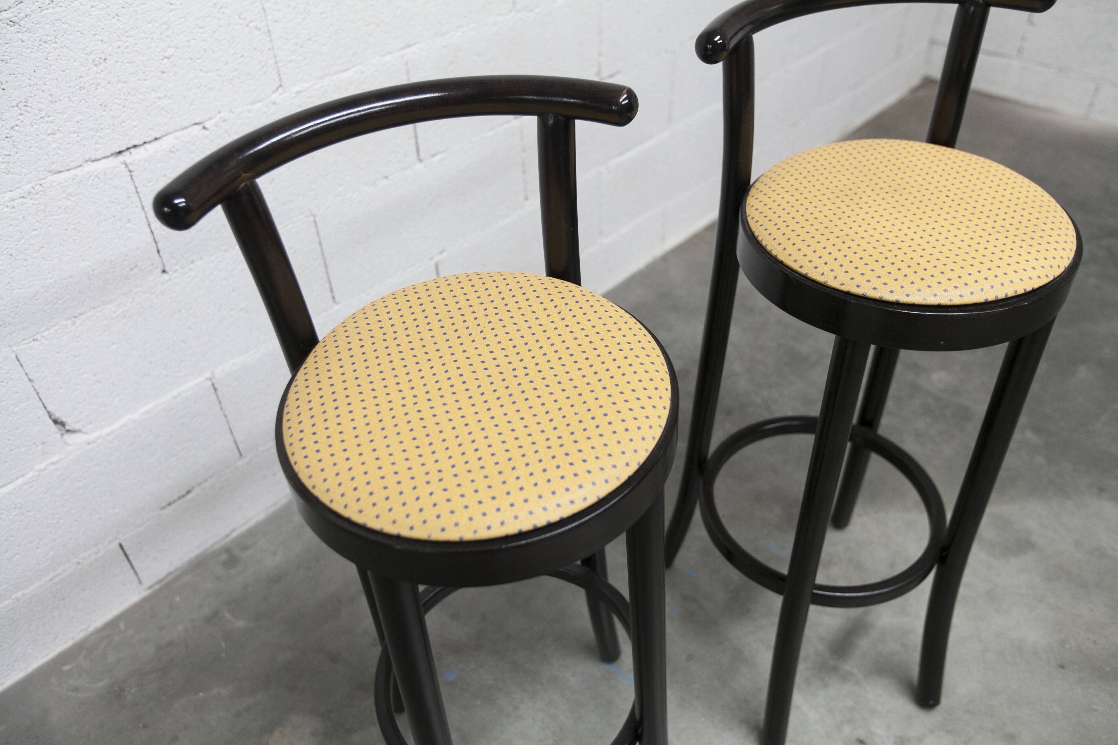 Pair of Baumann Dialog model stools in black and yellow and blue imitation leather, 1990