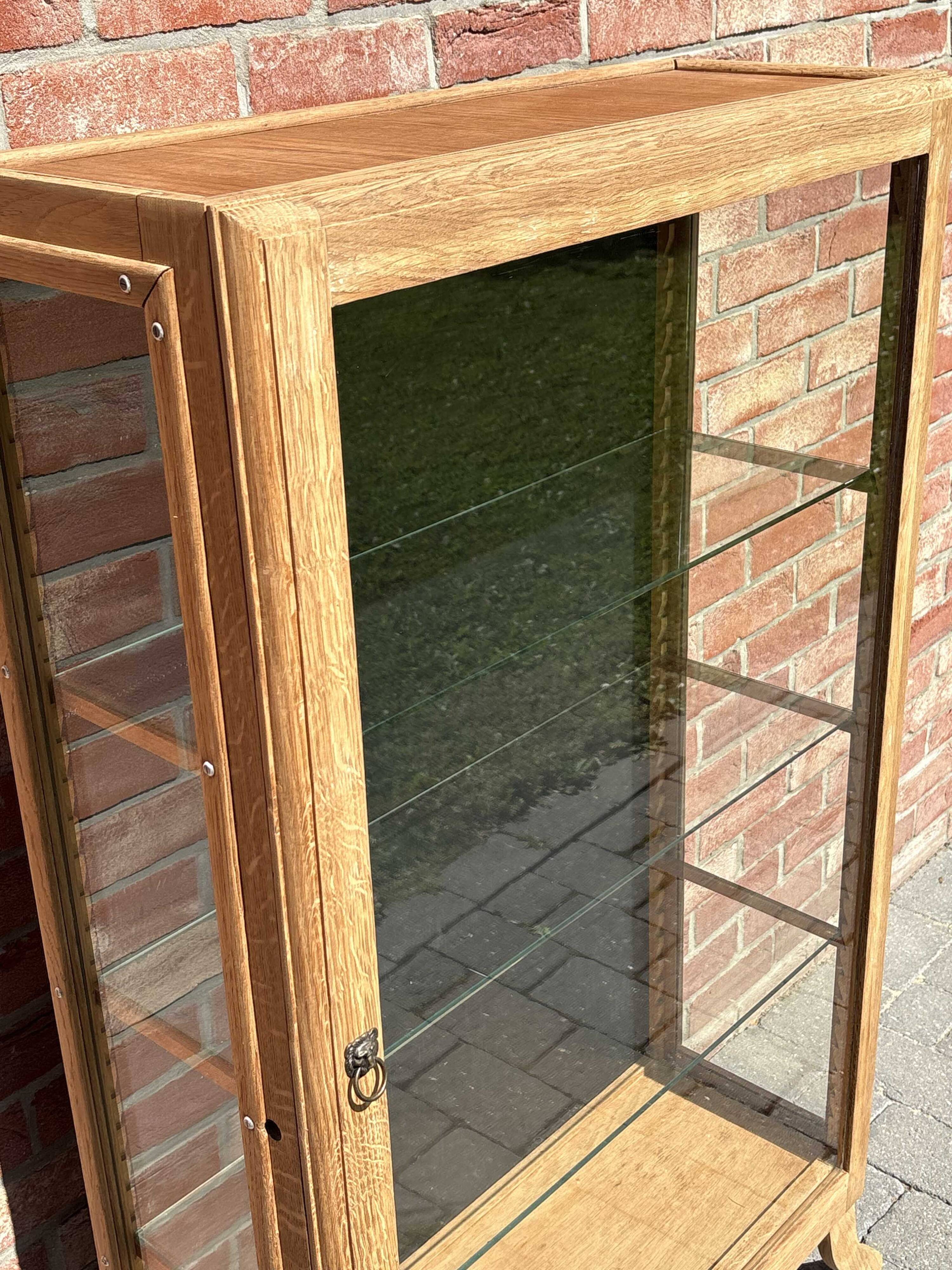 Restored antique oak display cabinet, black background, glass shelves.