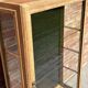 Restored antique oak display cabinet, black background, glass shelves.