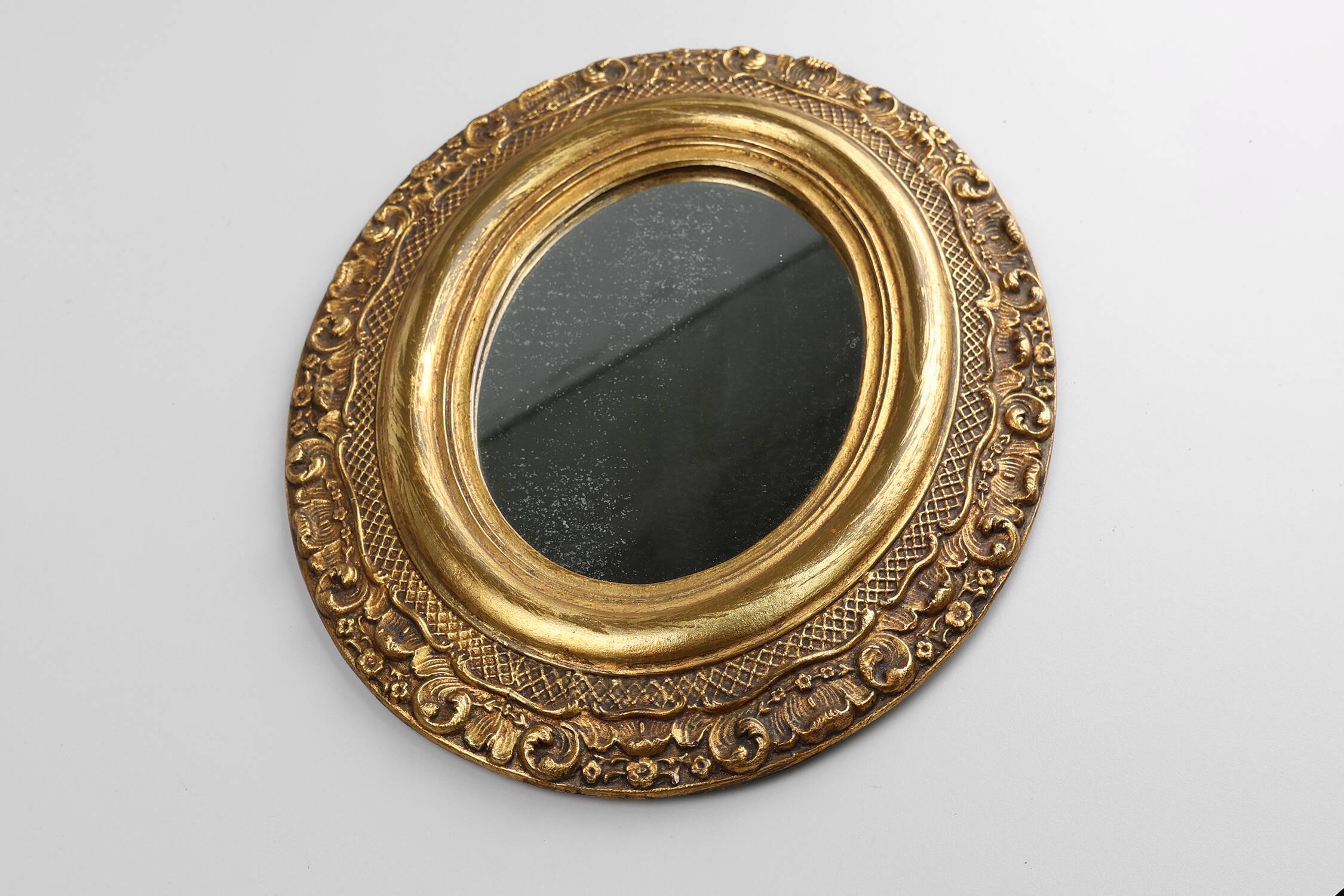 French Baroque style oval mirror in gilded wood with floral decorations