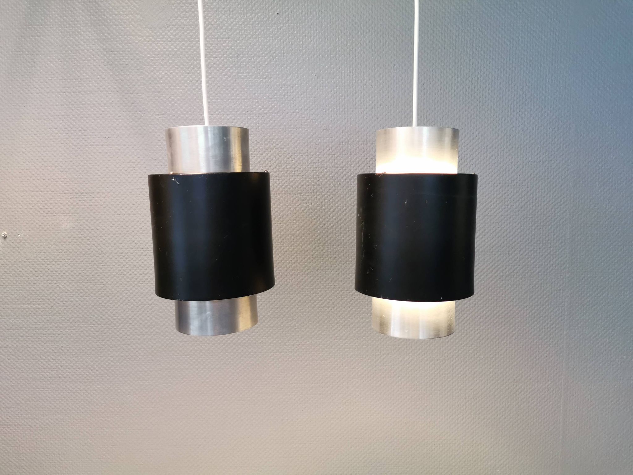 A set of beautiful cylinder shaped hanging lamps in silver color with black "ring" Danish 1970s.