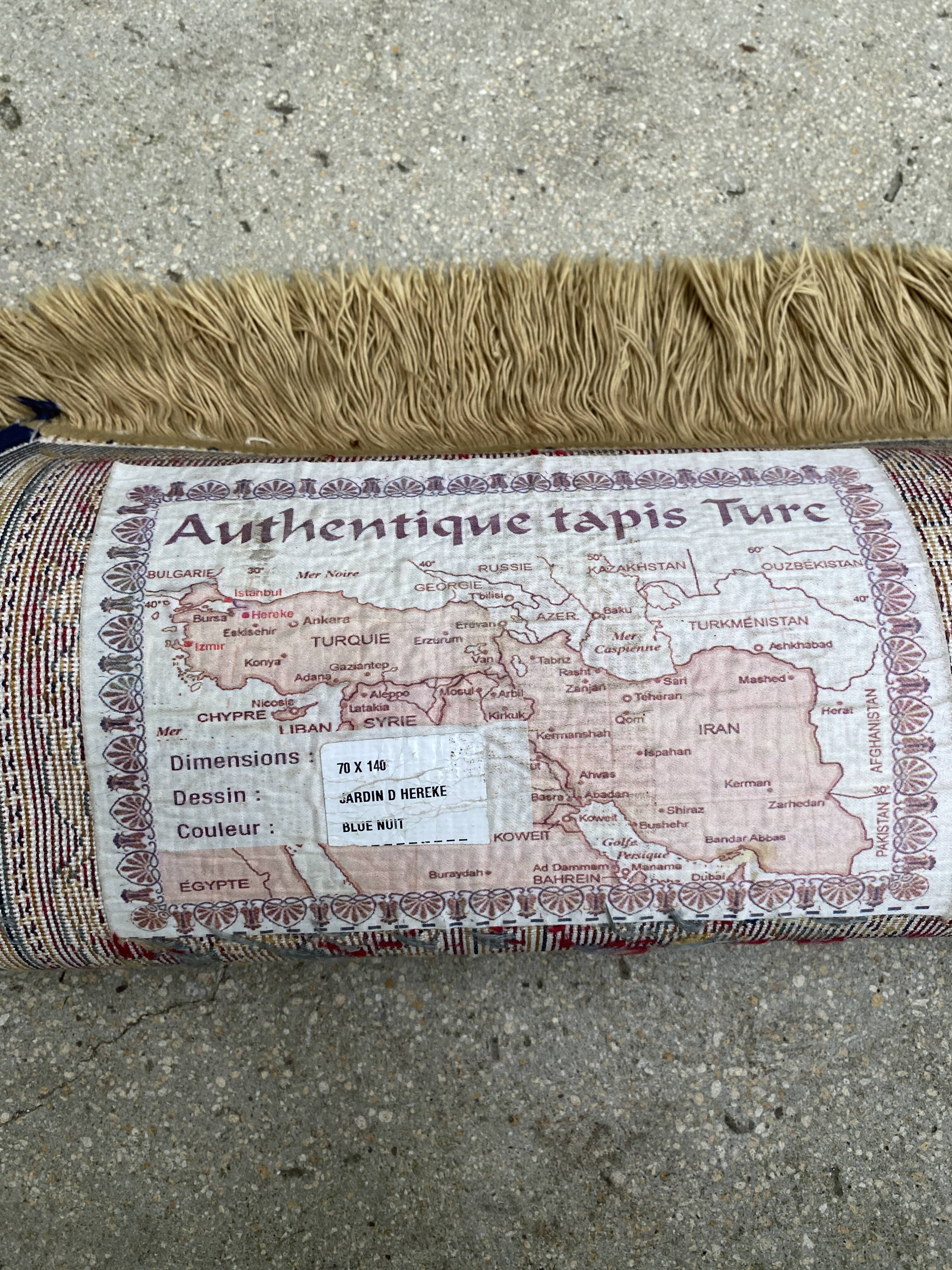 Vintage mechanical Turkish rug with box decoration on a red and navy blue background 139 x 68 cm