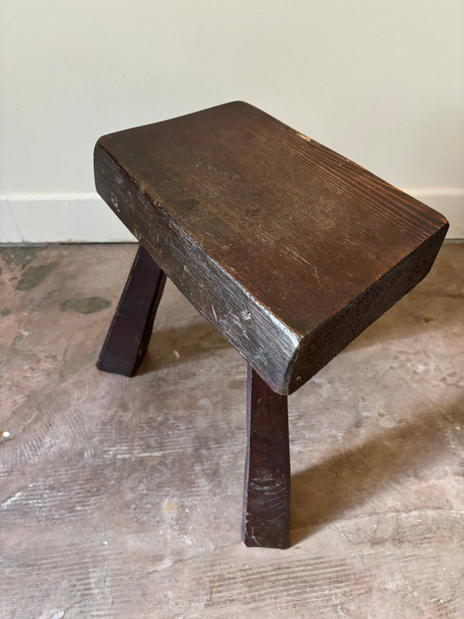 Brutalist tripod stool in dark wood