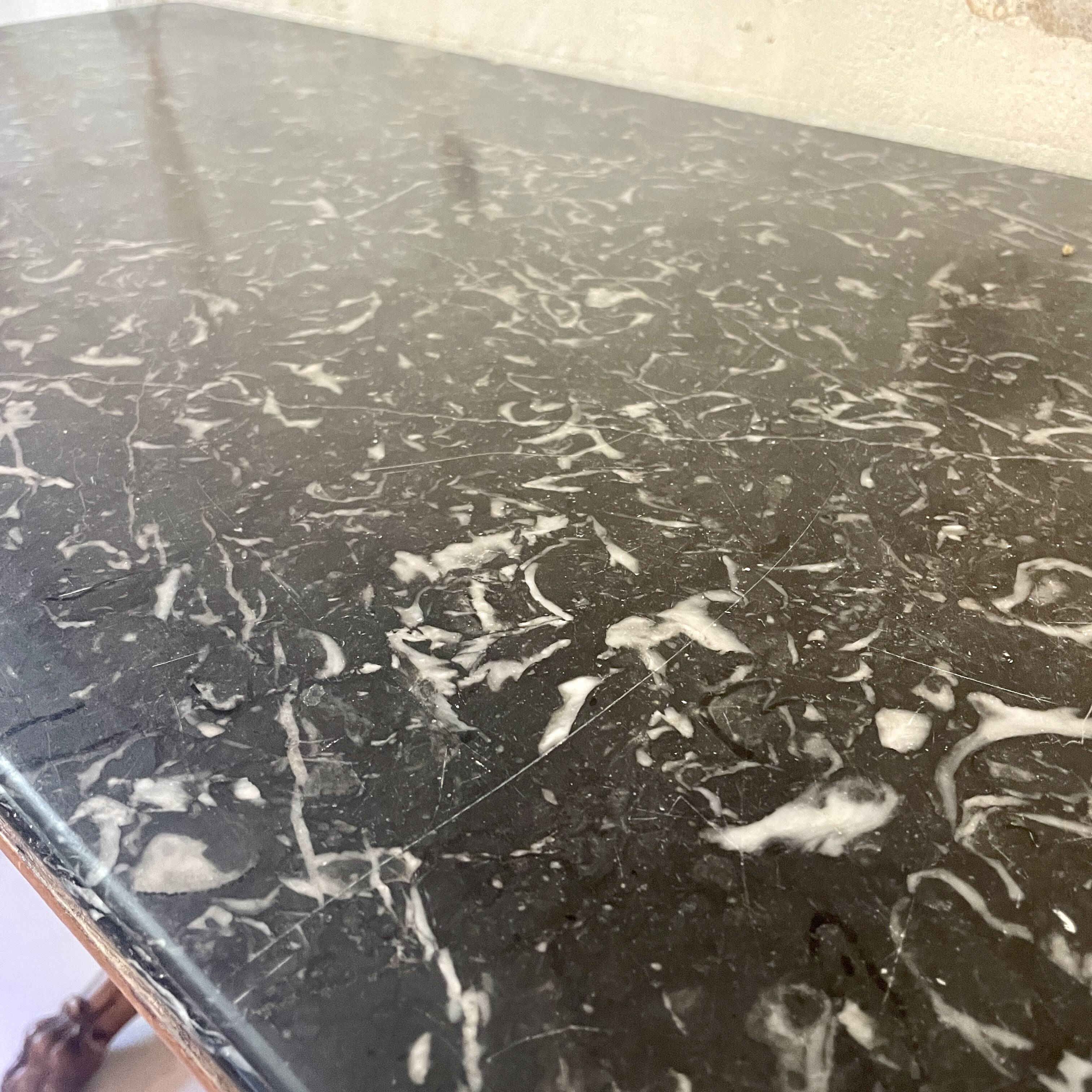 Console inlaid with black marble and lion's paw legs.
