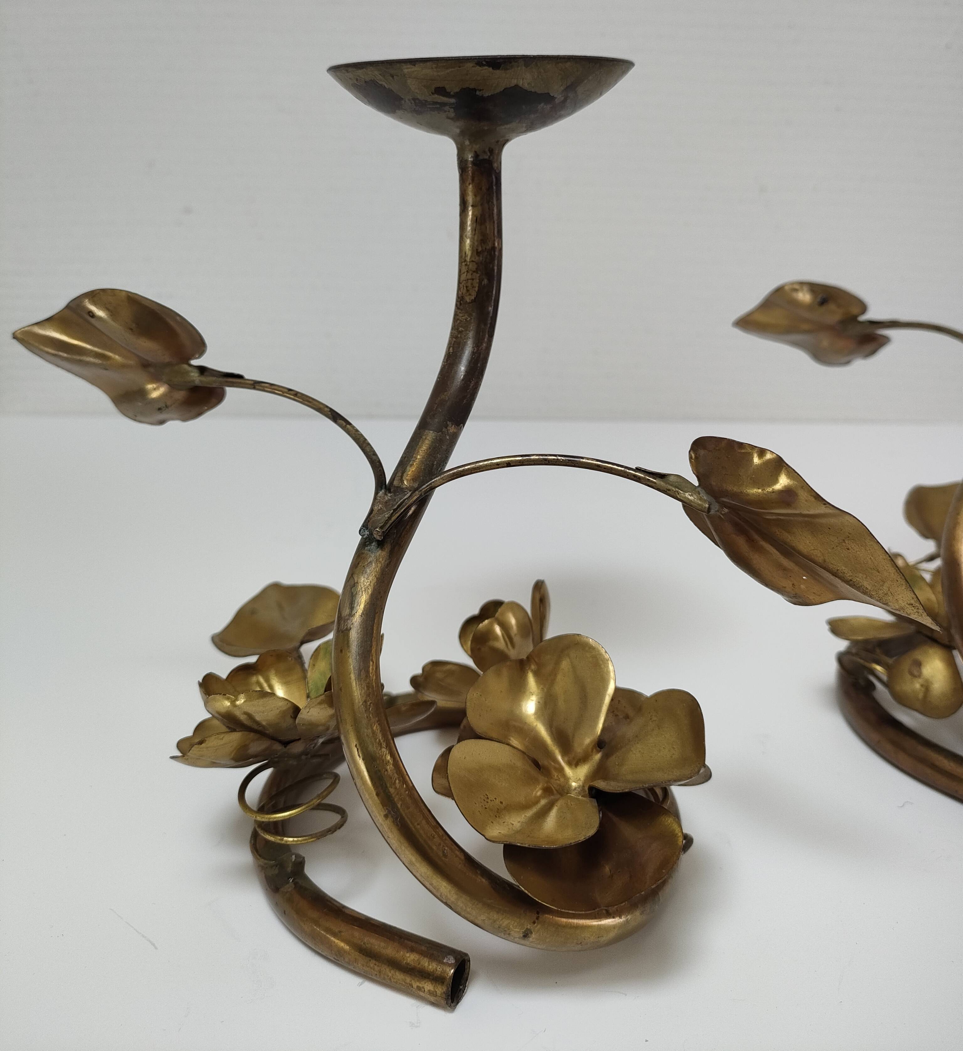 Pair of brass candle holders decorated with patinated metal flowers