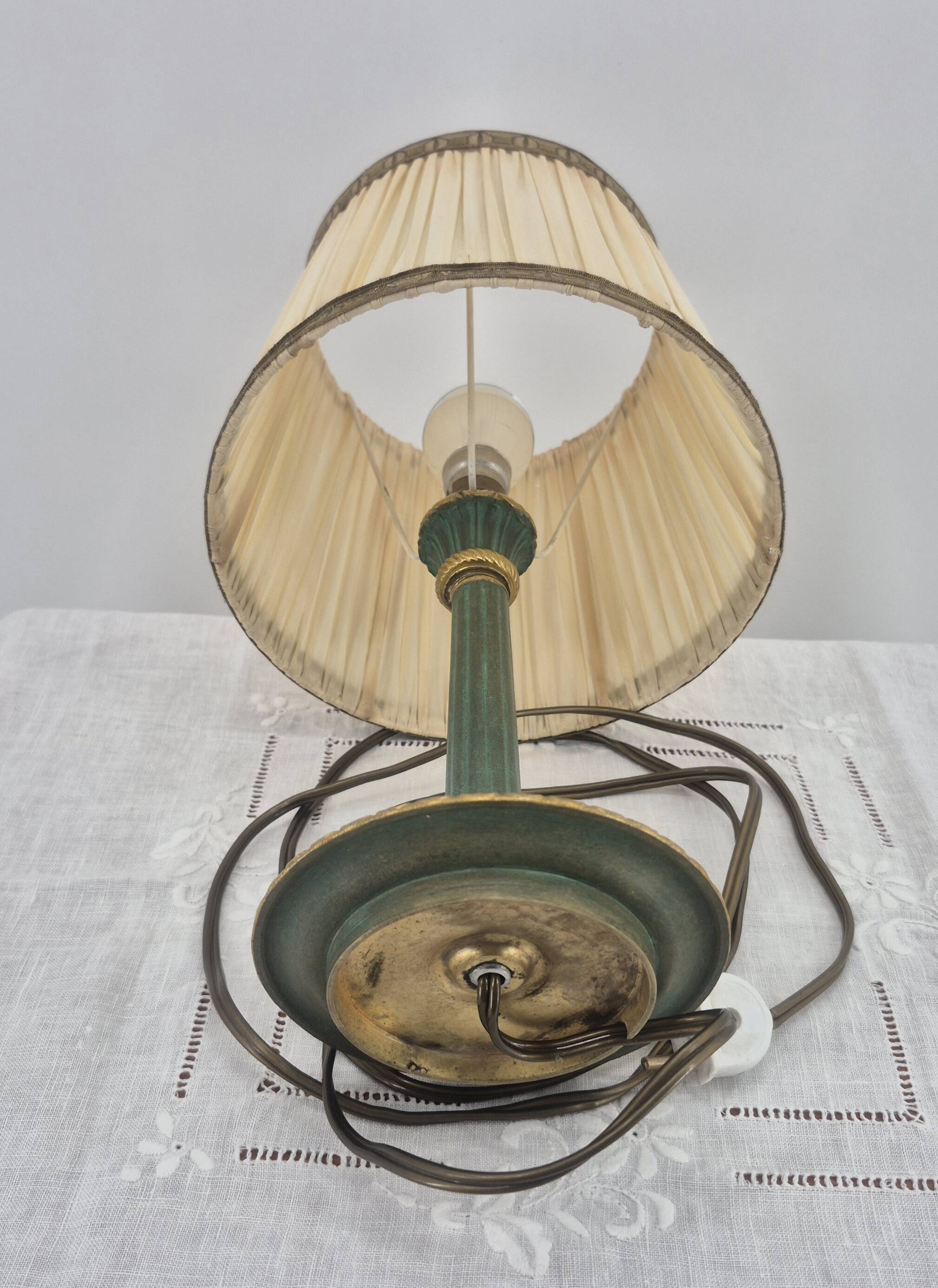 Brass table lamp with green patina and empire-style fabric shade.