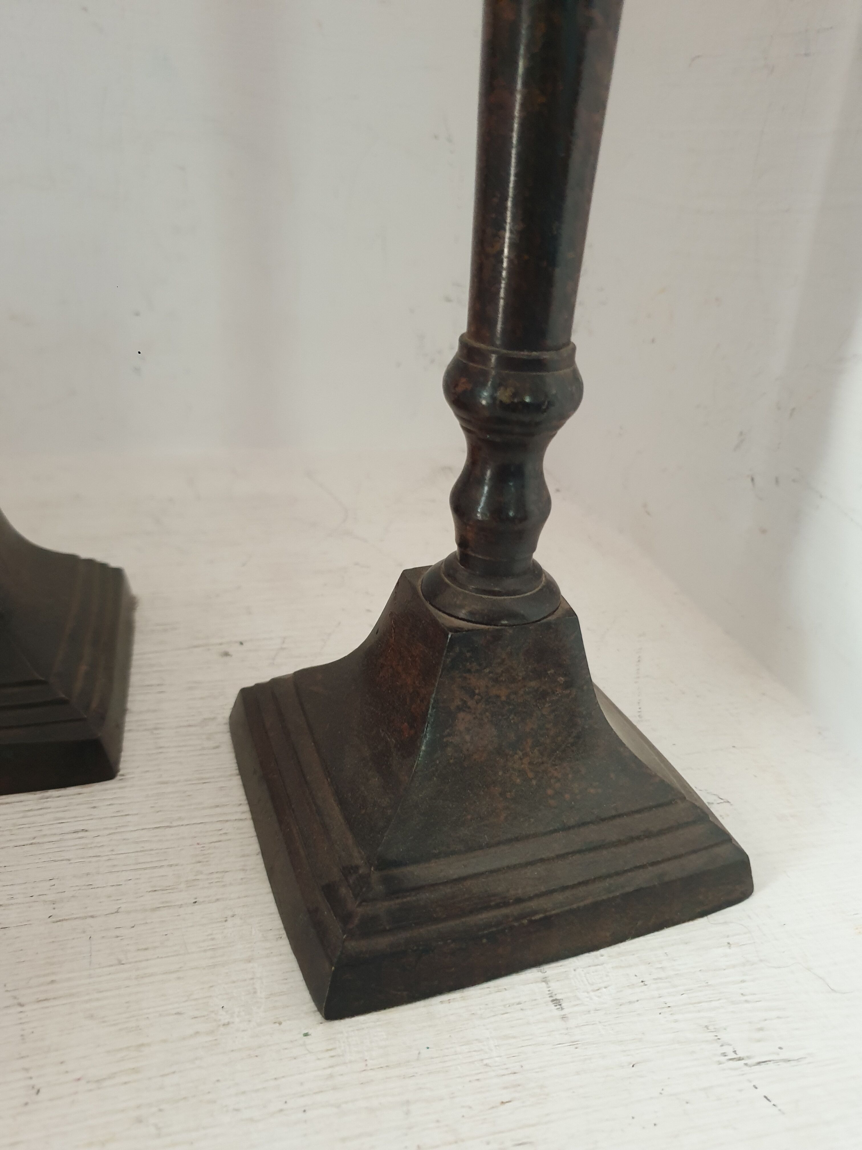 Two pairs of patinated brass candle holders