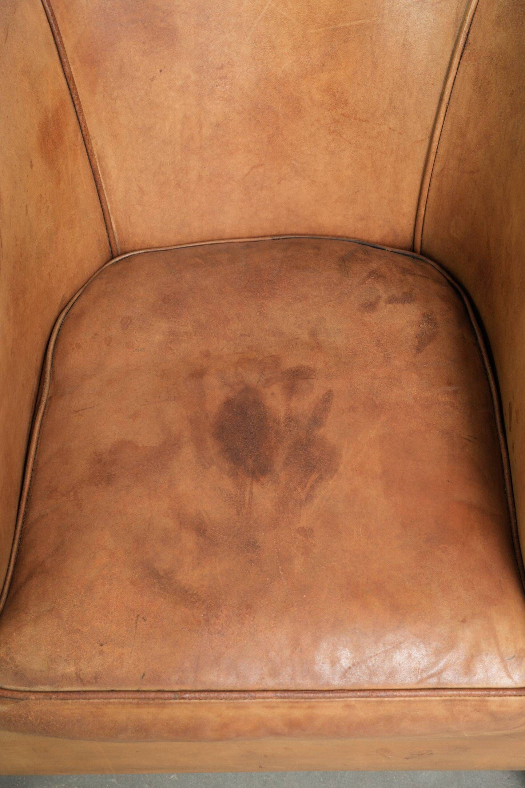 Fauteuil club en peau de mouton confortable de couleur cognac.
