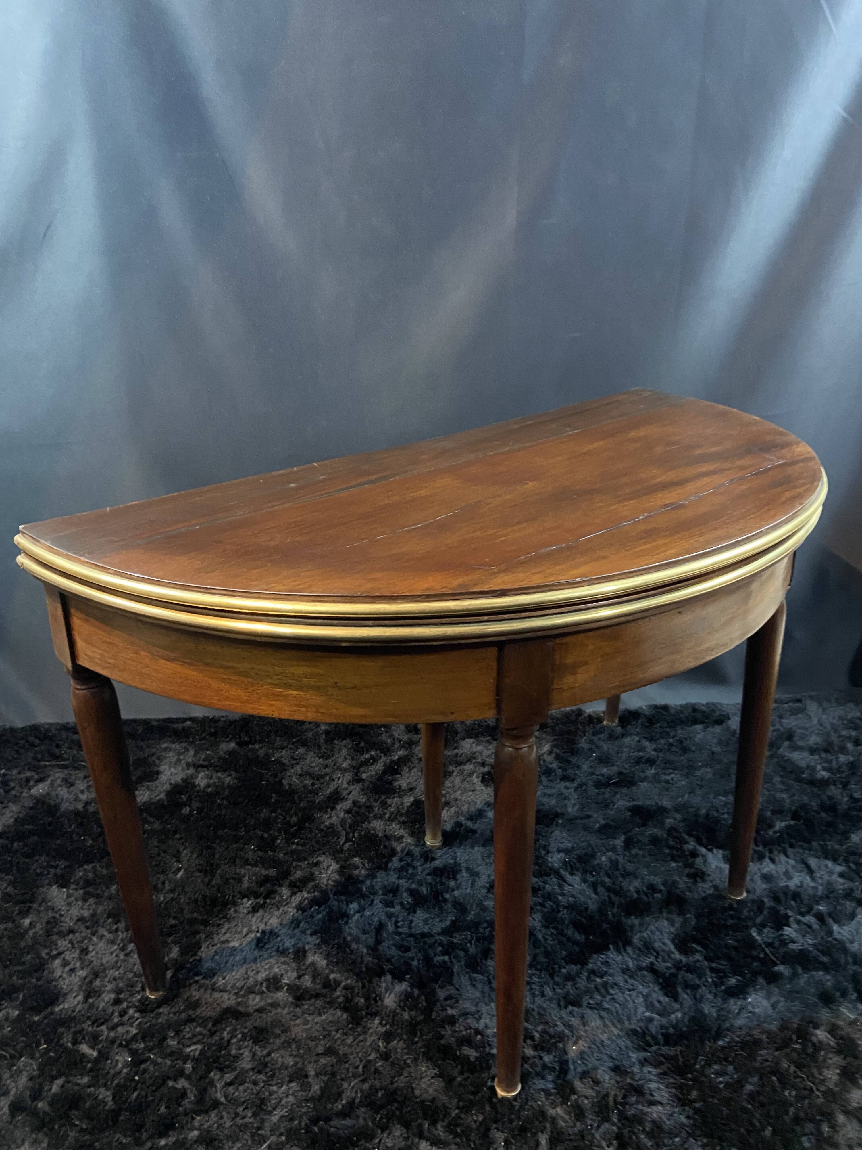 A Louis XVI period mahogany half-moon table forming a console/games table
