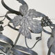 Vintage black wrought iron bottle holder decorated with vine leaves
