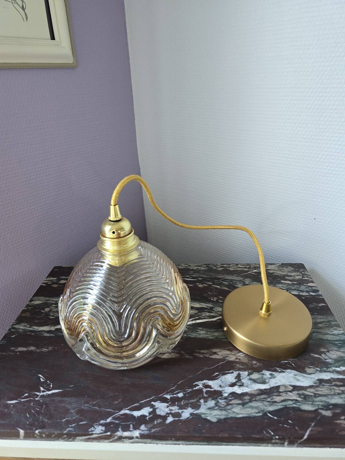 Suspension with amber moulded glass globe featuring wavy patterns.