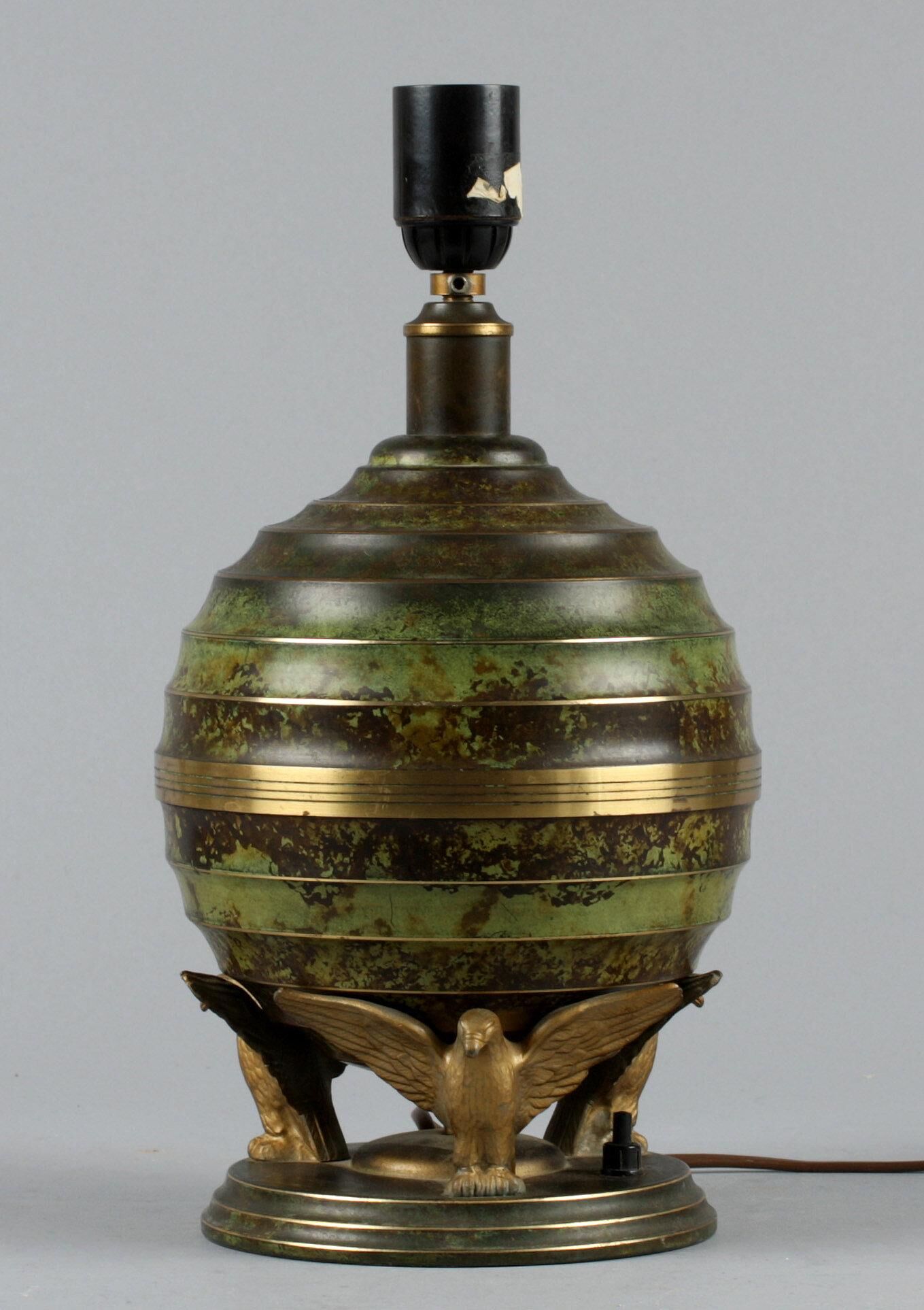 Art Deco table lamp in patinated bronze with eagles holding a globe, France 1940.