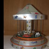 Old toy made of wood, aluminum and fabrics, animated and musical merry-go-round
