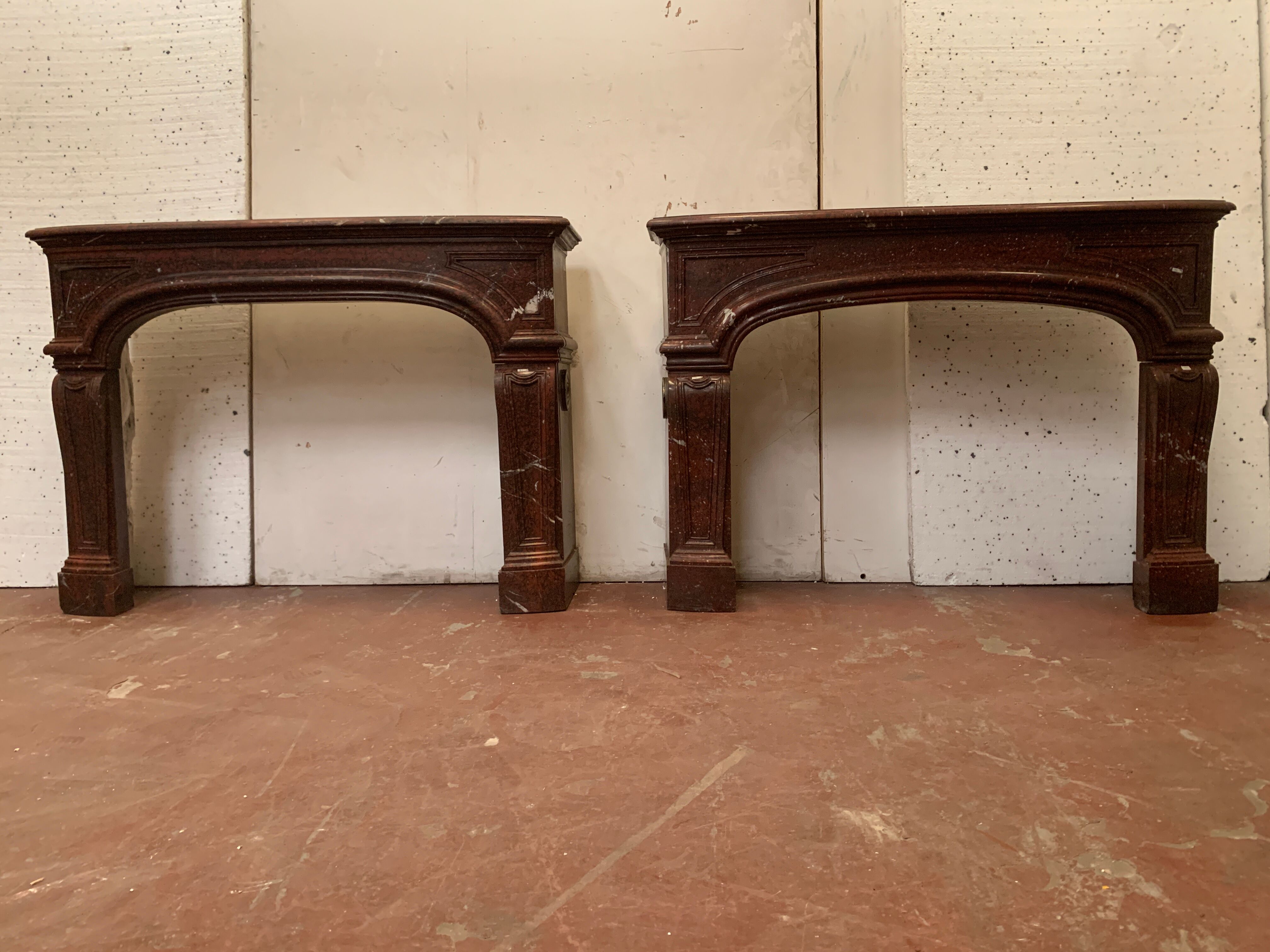 Pair of Louis XIV style fireplaces in red cherry marble. XIX century.