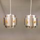Two Space-Age hanging lamps, in silver-coloured aluminium with orange prisms.