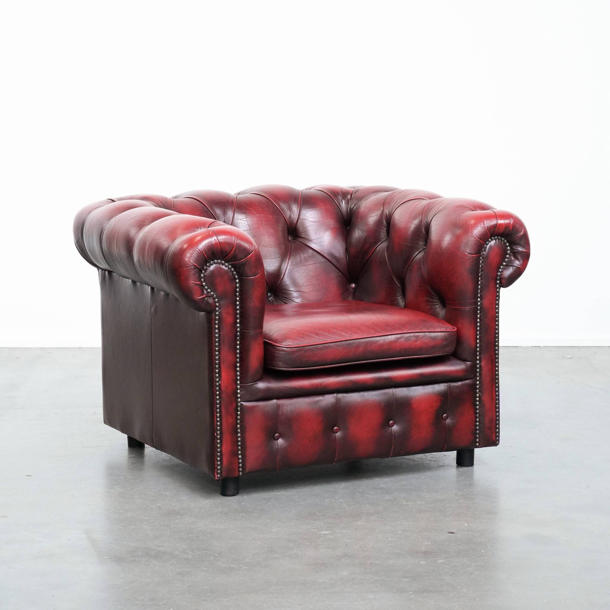 Red English cowhide Chesterfield armchair finished with decorative nails