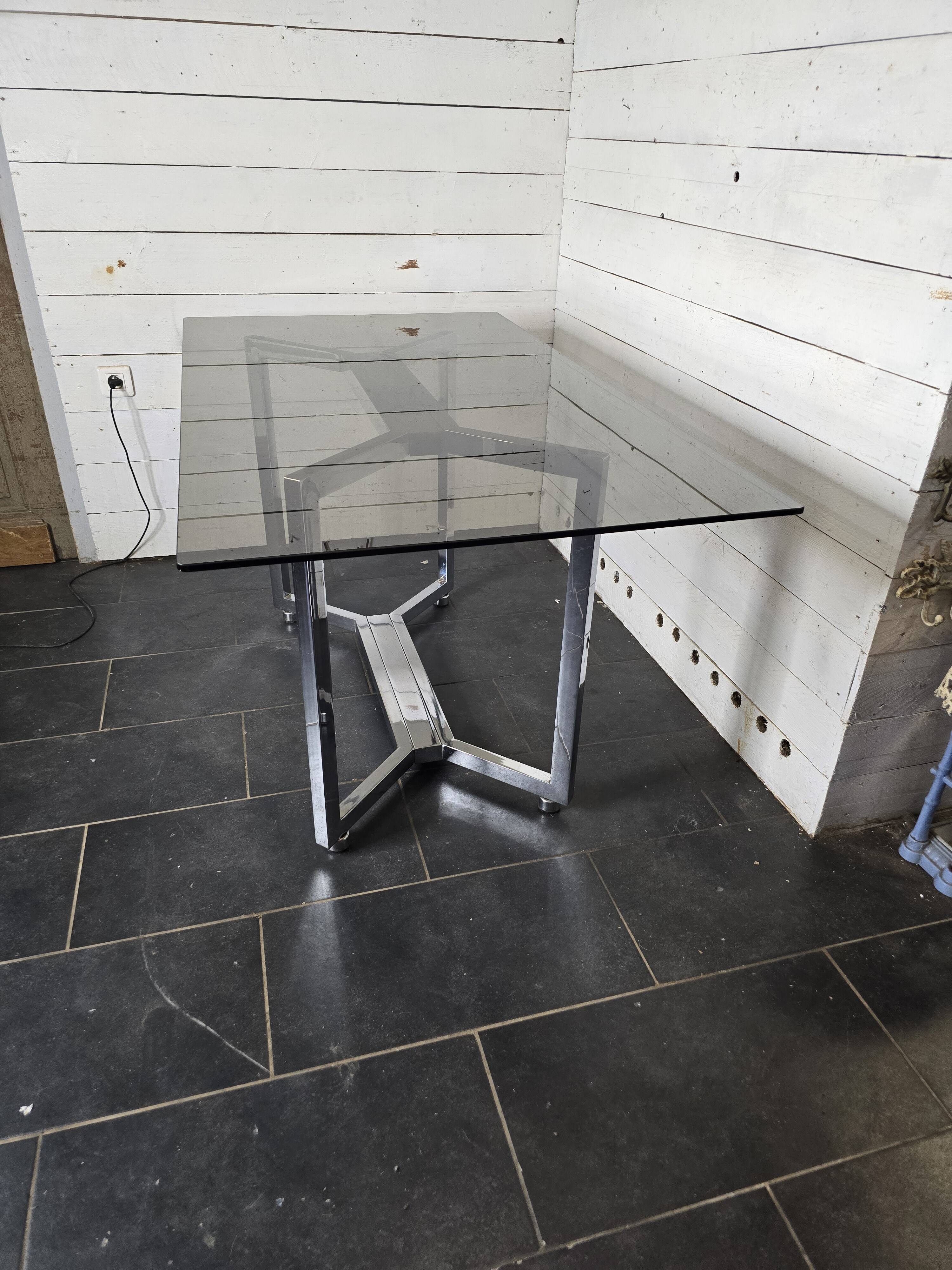 Table en métal chromé dessus verre fumé
